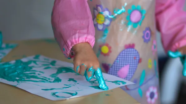 A child finger painting.