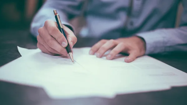 The hands of an individuals writing on paper