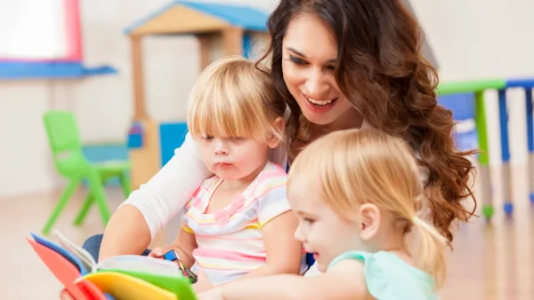 Adult reading to two toddlers