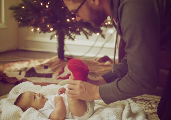 Adult playing with a baby on the floor
